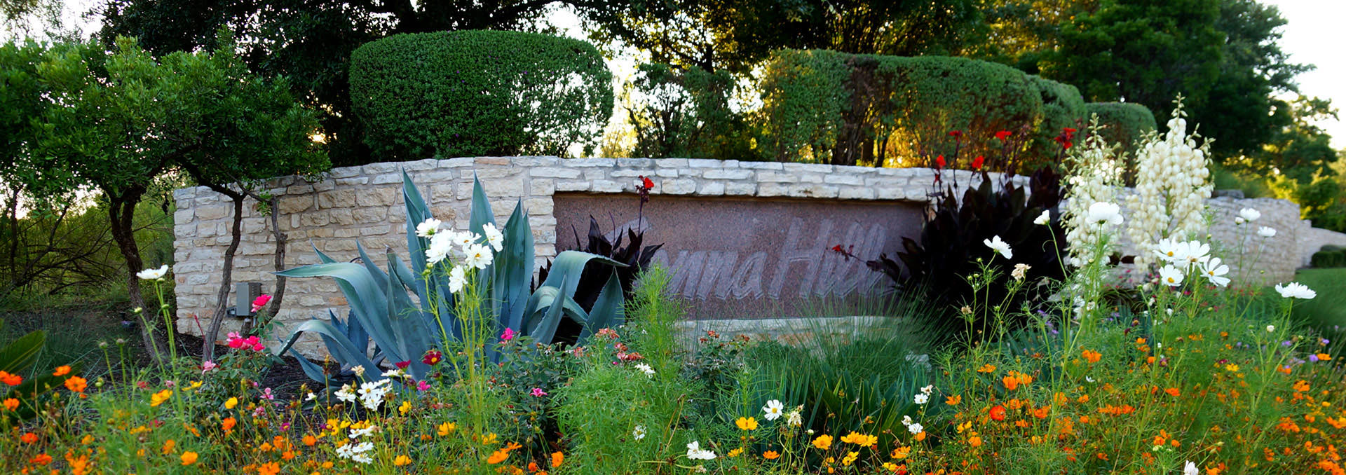 Senna Hills limestone entrance monument surrounded by wildflowers